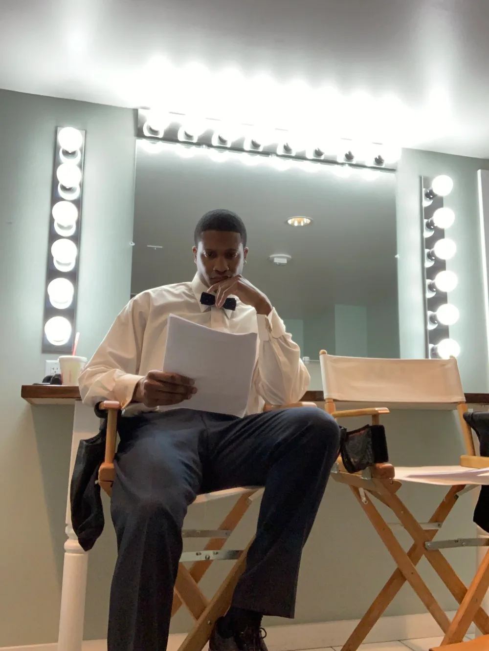 Jae in a dressing-room mirror, reading a script